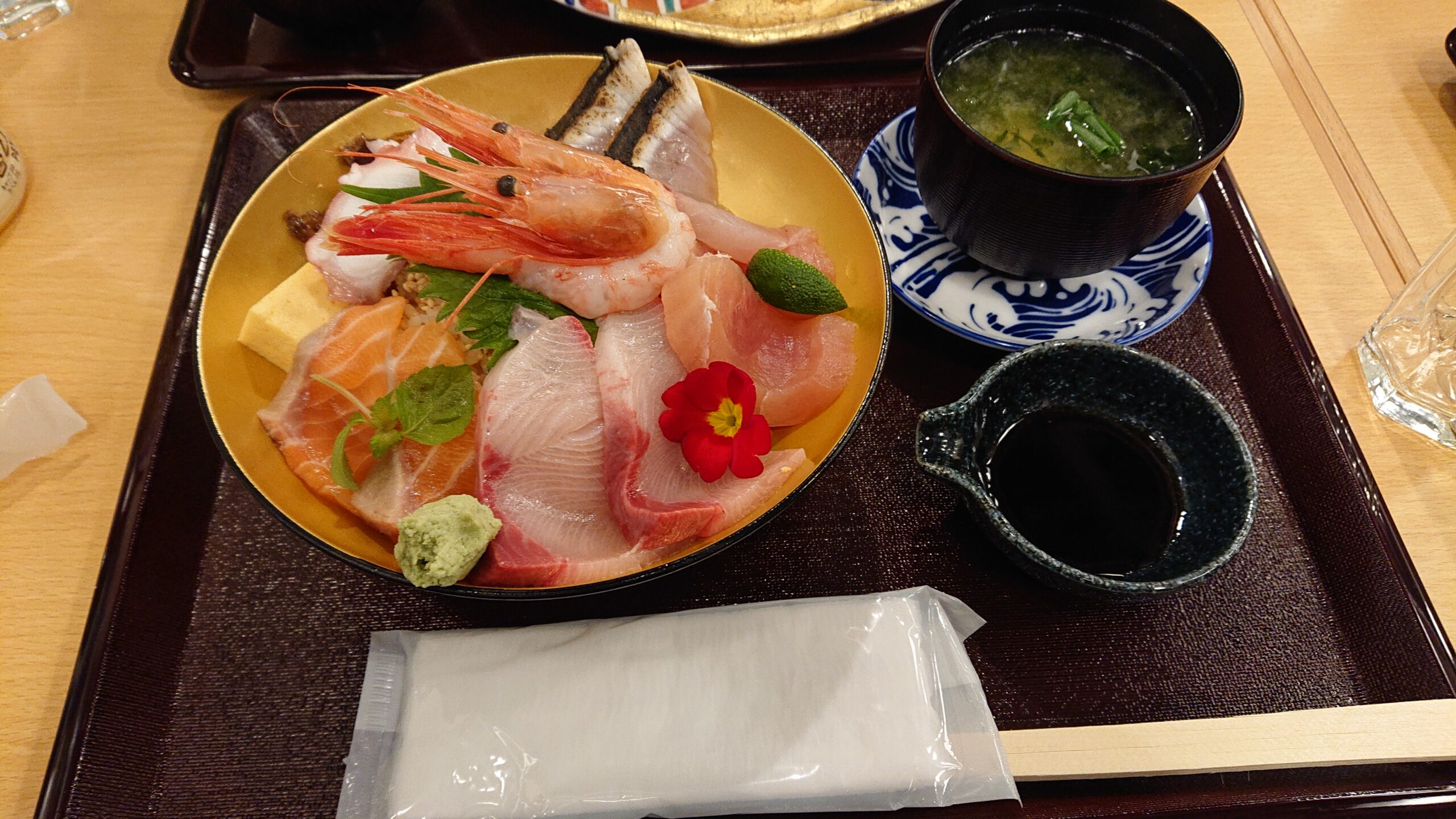 近江町市場內的新鮮海鮮丼，碗中堆滿甜蝦、鮪魚、海膽等豐富食材