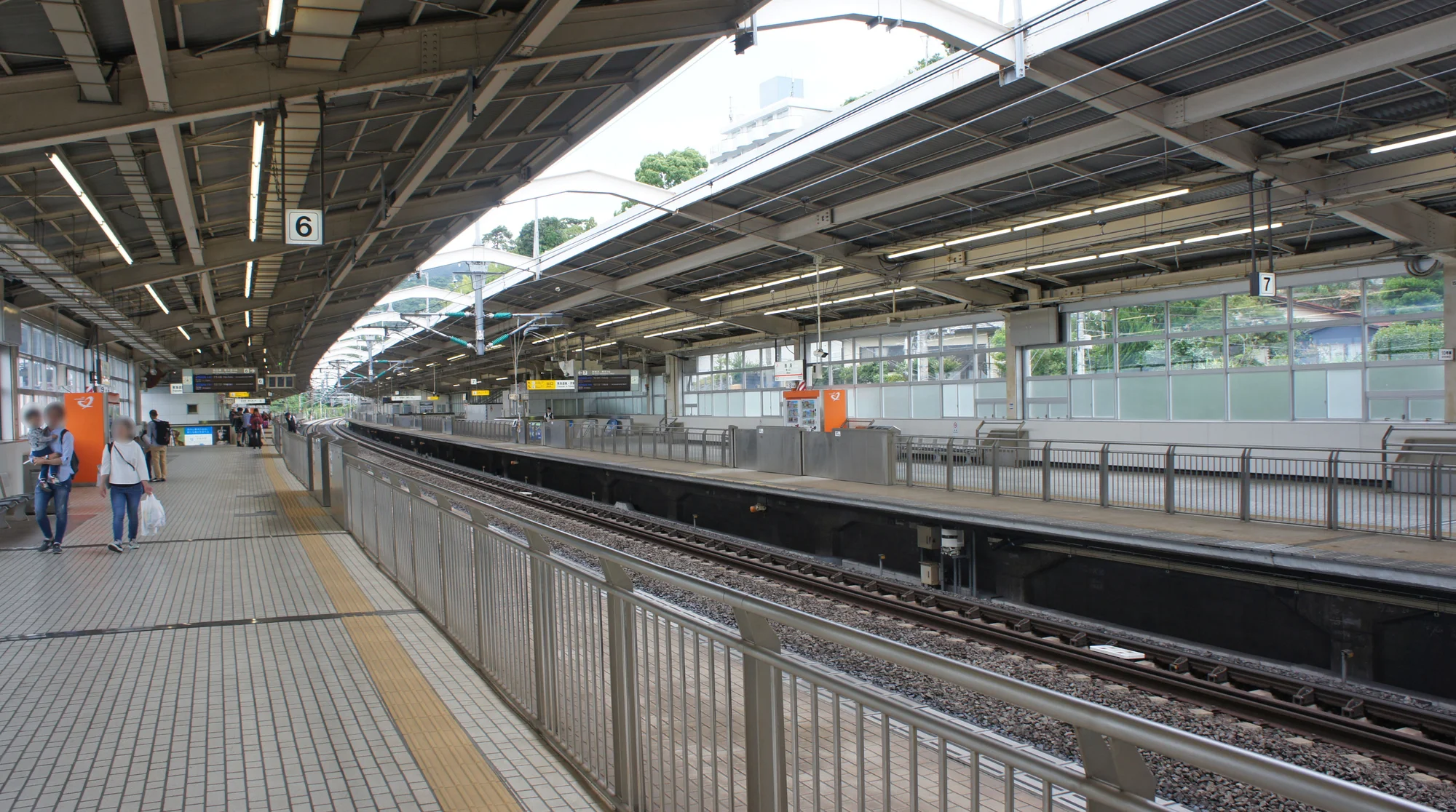熱海站月台與新幹線列車，背景可見相模灣與山丘
