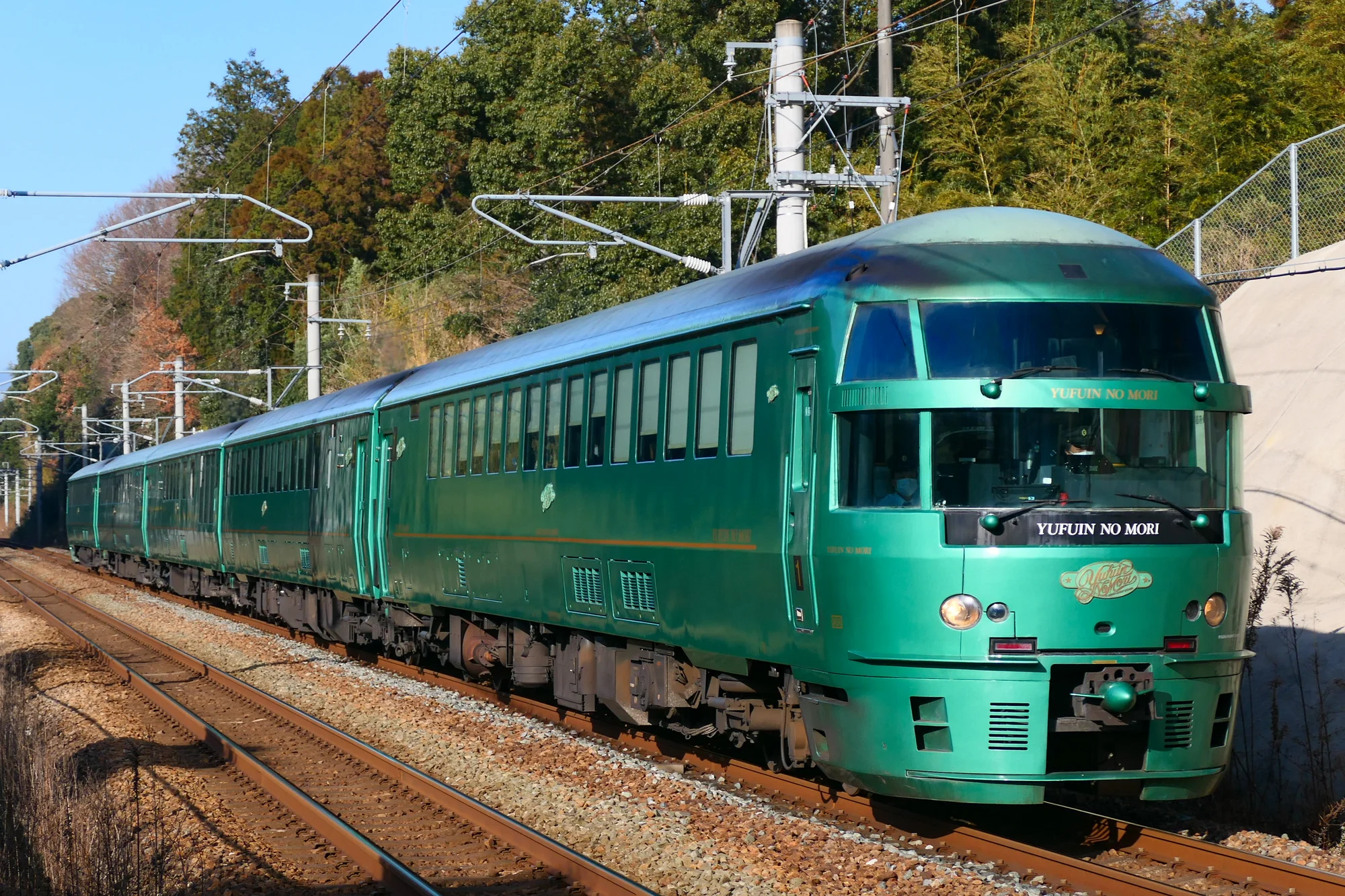 JR九州觀光列車由布院之森號，經典復古綠色車身行駛在田園間
