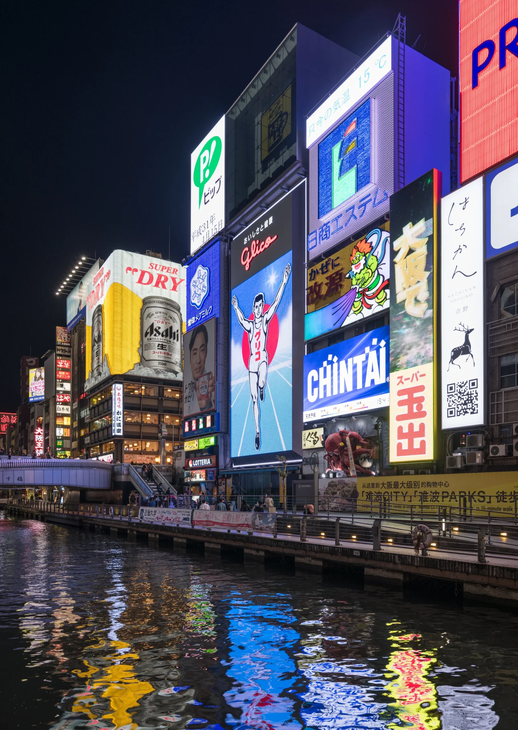 大阪難波道頓堀夜景，家庭旅客在格力高跑步人看板前合影，河岸燈火通明