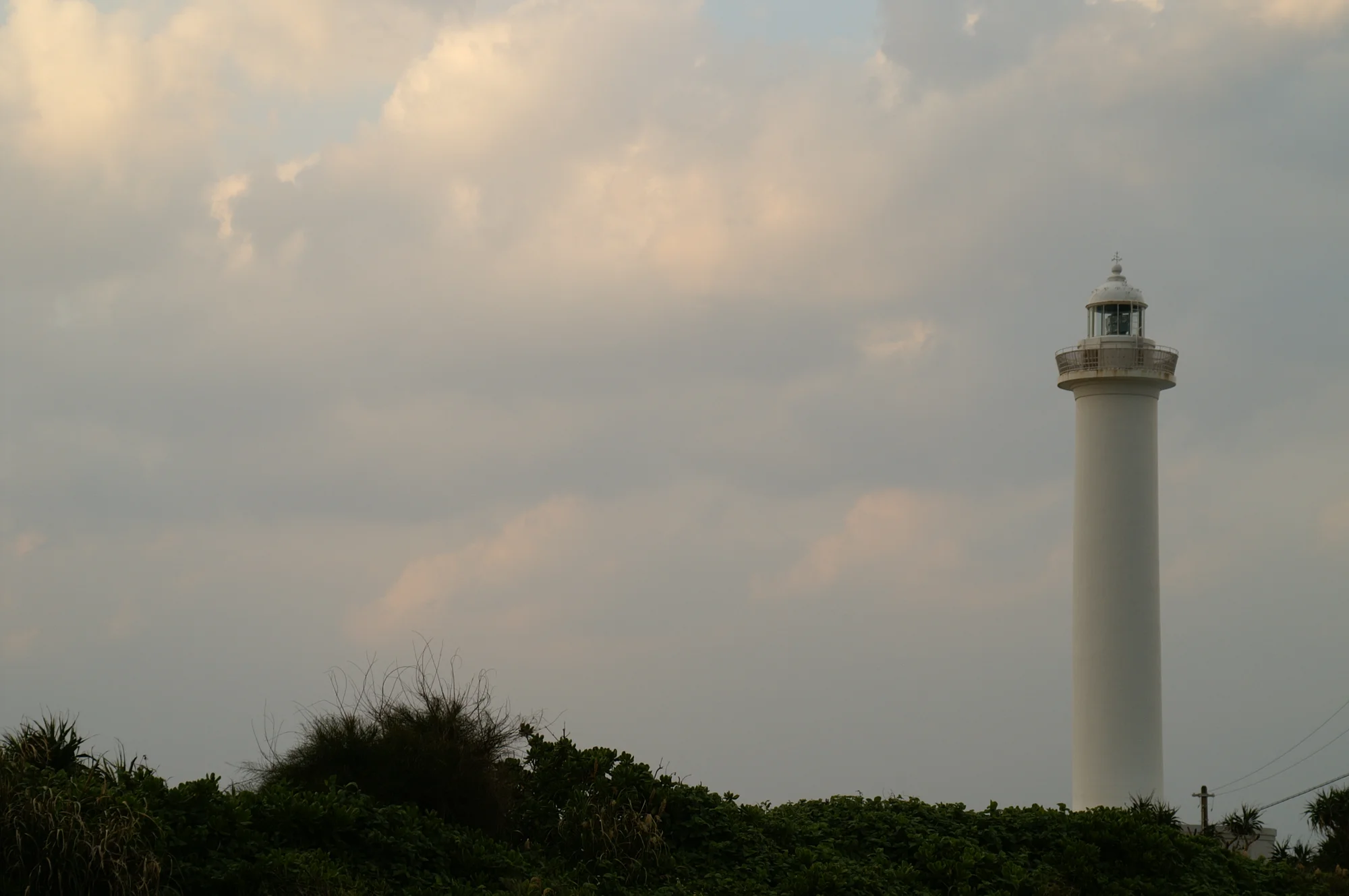 沖繩讀谷村殘波岬斷崖絕景，白色燈塔矗立於珊瑚礁岩壁上方