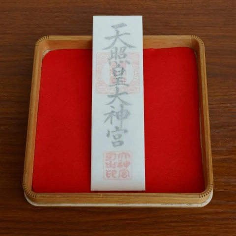 香椎宮御朱印與御守室內展示，木盤放置紅布及印字白紙籤。