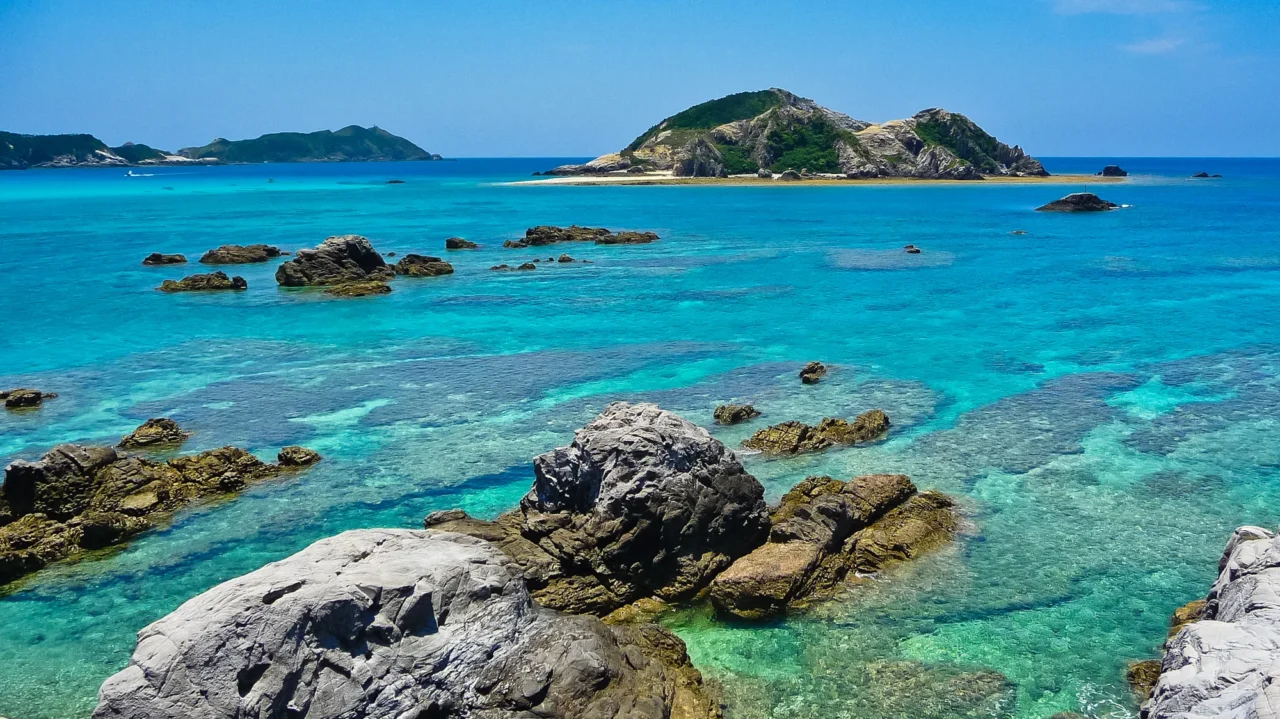 座間味島慶良間浮潛海域，海水透明度超越沖繩本島，遊客在海中賞珊瑚與魚羣。