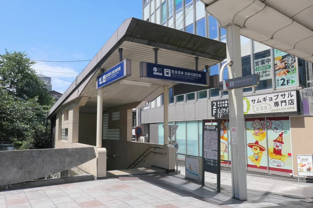 阪急京都河原町站1-B出入口,藍色站名看板與通往月台的樓梯,白晝街景。
