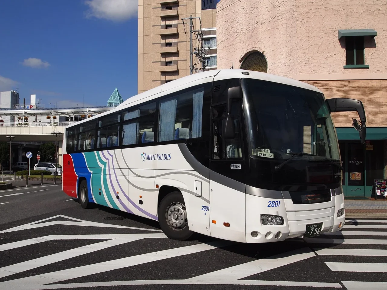 名鐵巴士的白色高速巴士，車身有紅藍綠波浪塗裝與 MEITETSU BUS 字樣。