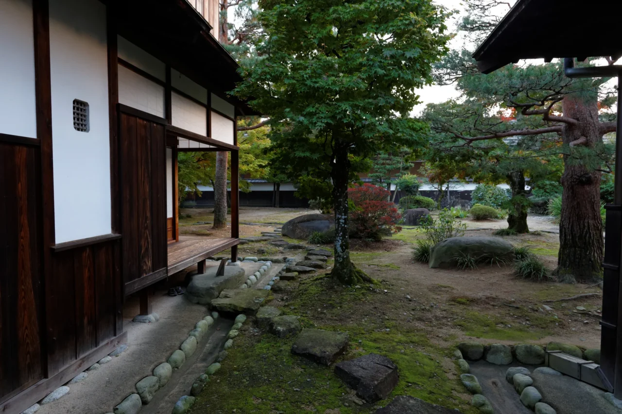 高山陣屋書院造長廊，深色梁柱結構與日式木質門框，建築細部工法展現。