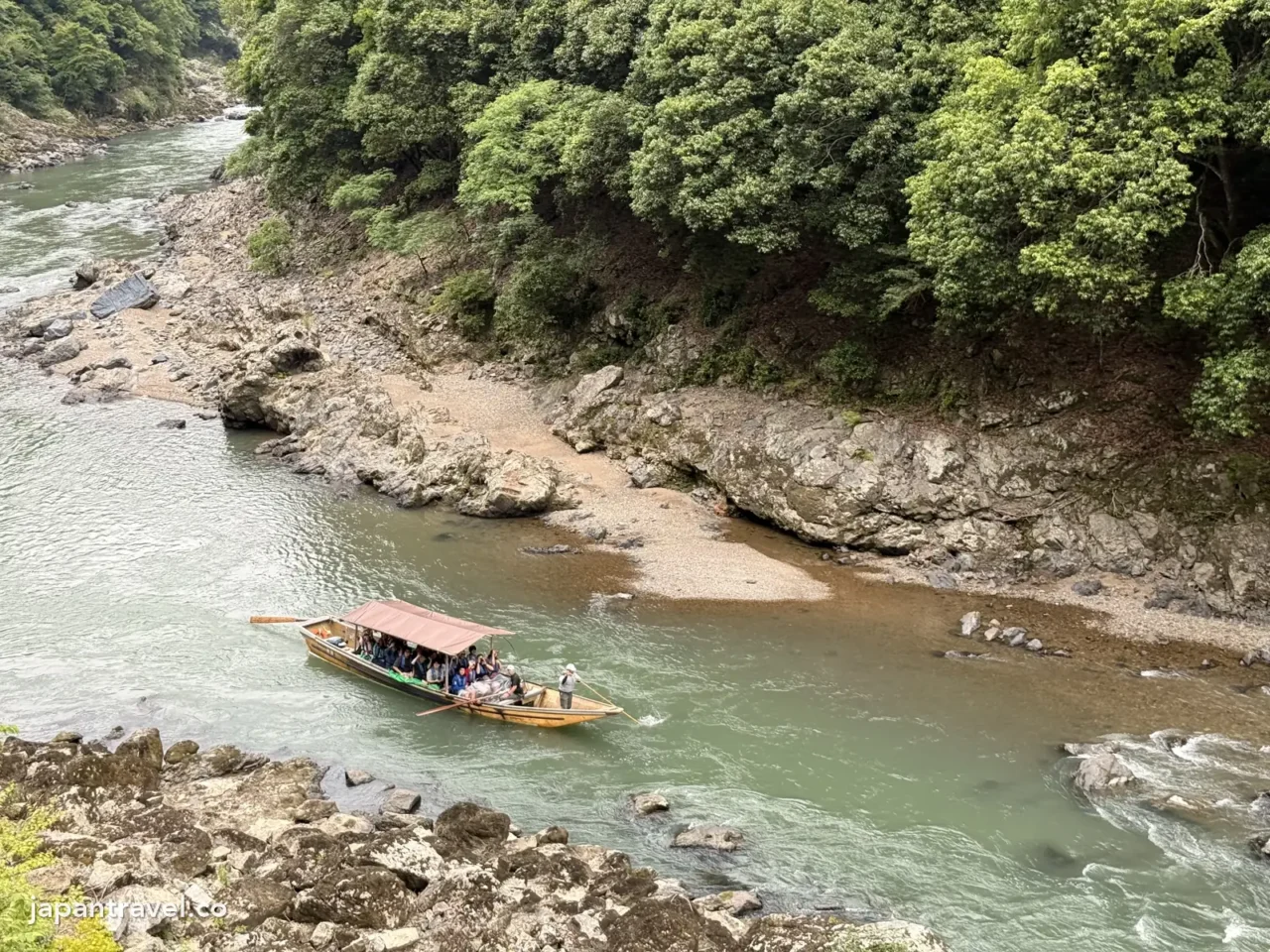 從嵯峨野小火車往下看,保津川遊船正駛過保津峽