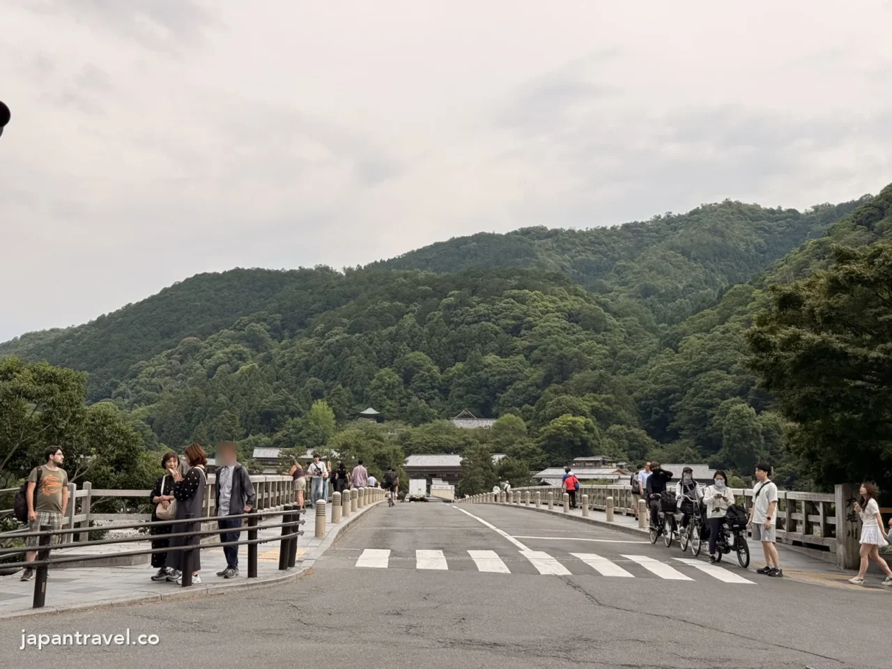 傍晚的渡月橋，橋上有不少行人和單車